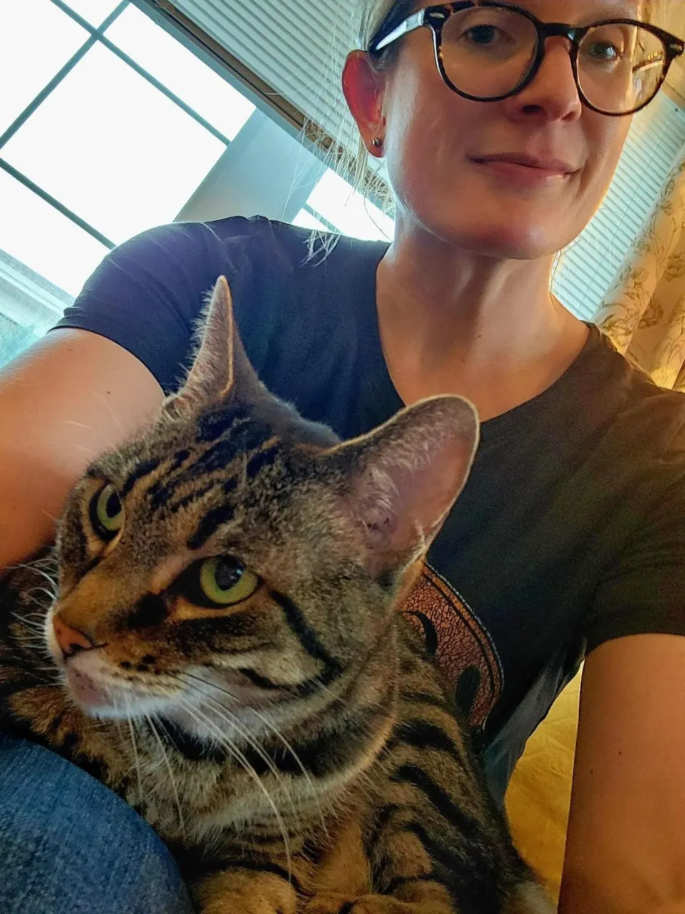 Stacy Rankin, in glasses, with a brown tabby cat