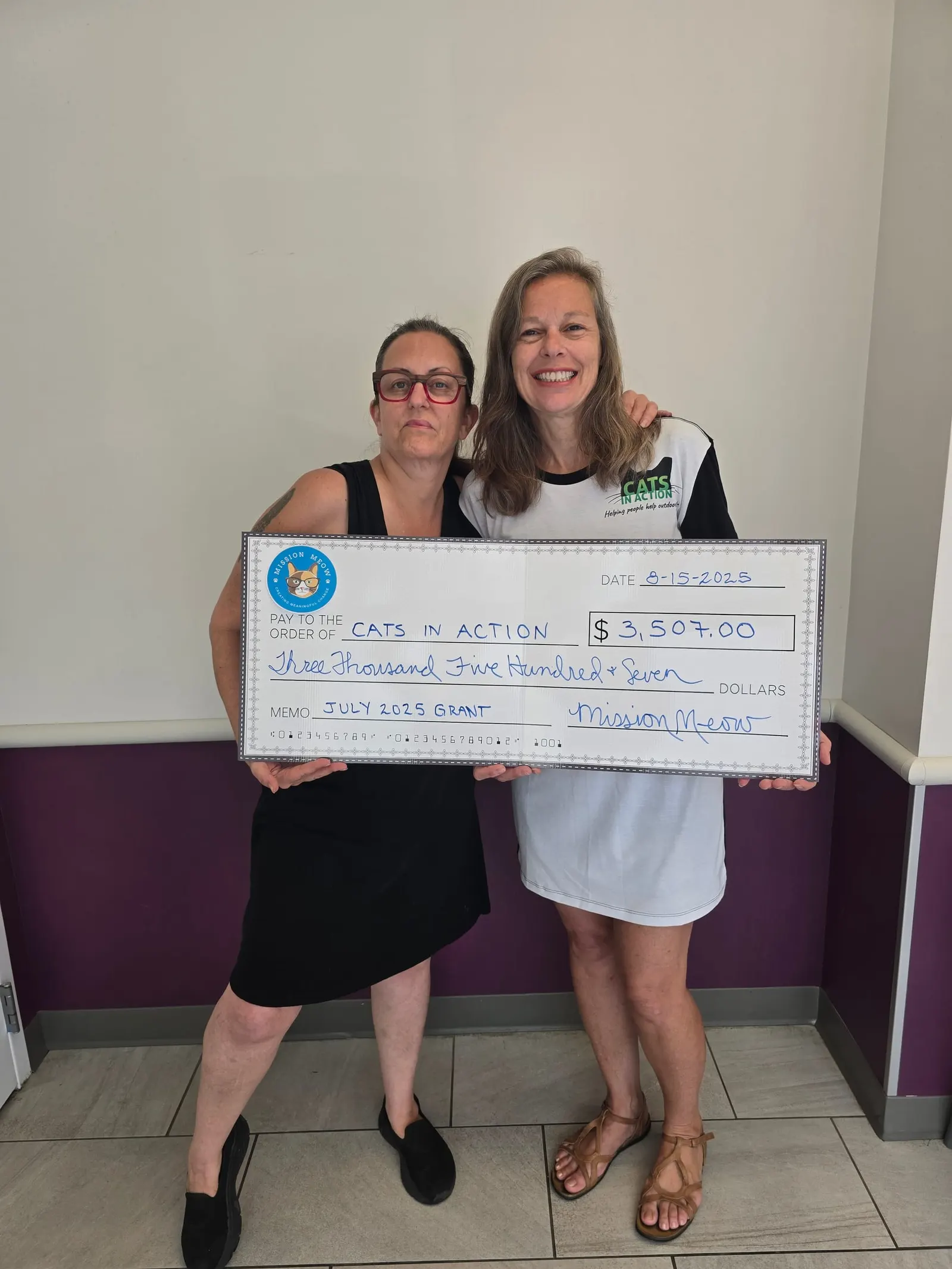 Two women from Cats In Action with their check