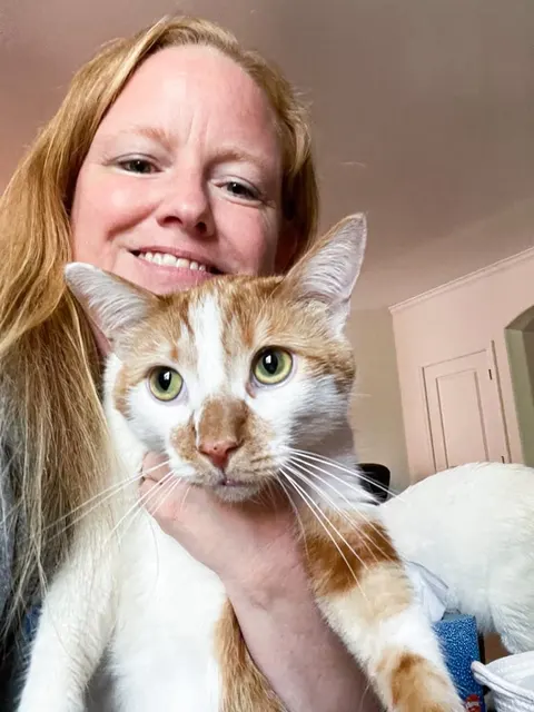 Megan Martin holding an orange-and-white cat