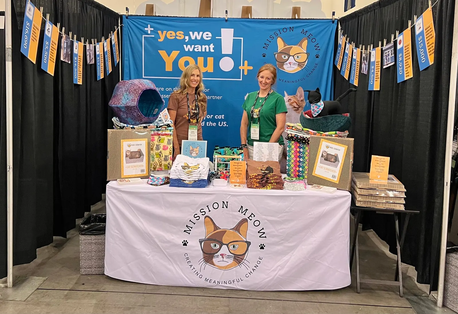 Sally Williams and a colleague at the Mission Meow booth, under a banner inviting businesses to partner: “Yes, we want you!”